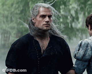 A Man With Long Gray Hair Is Standing Next To A Woman In A Blue Jacket . GIF