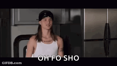 A Man With Long Hair And A Bandana Is Standing In Front Of A Refrigerator . GIF