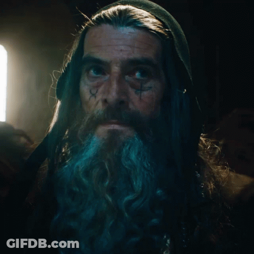 A Man With Long Hair And A Beard Has A Tattoo On His Face That Says ' X ' GIF
