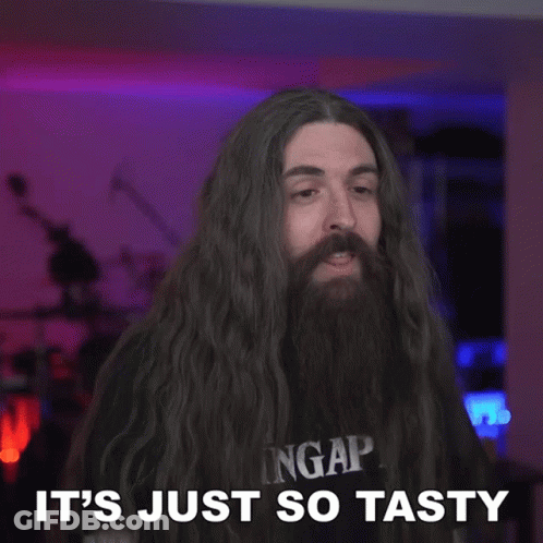 A Man With Long Hair And A Beard Has The Word So Tasty Above Him GIF