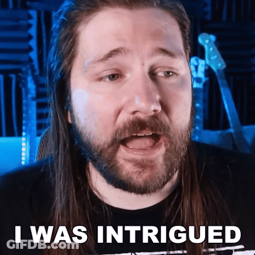 A Man With Long Hair And A Beard Has The Words I Was Intrigued Above His Head GIF