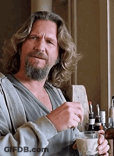 A Man With Long Hair And A Beard Holds A Glass Of Milk GIF