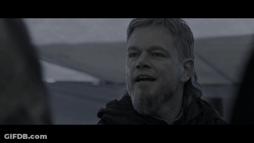 A Man With Long Hair And A Beard In A Dark Room GIF