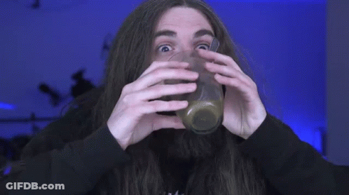 A Man With Long Hair And A Beard Is Drinking A Drink Through A Straw . GIF