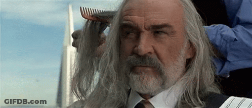 A Man With Long Hair And A Beard Is Getting His Hair Combed By A Man With A Comb . GIF