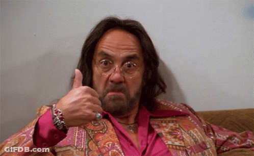 A Man With Long Hair And A Beard Is Giving A Thumbs Up Sign GIF
