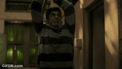 A Man With Long Hair And A Beard Is Holding A Chain Around His Neck And Shouting GIF