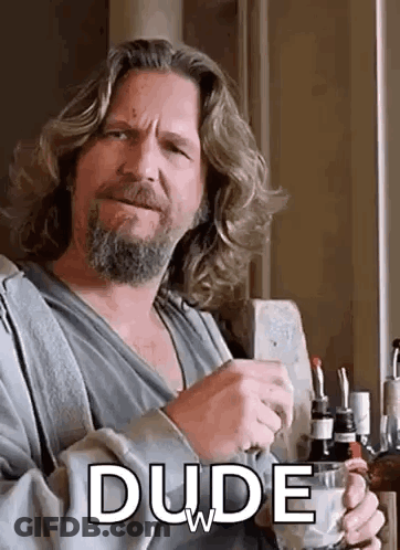 A Man With Long Hair And A Beard Is Holding A Cup Of Coffee And Drinking . GIF