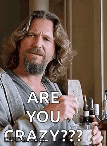 A Man With Long Hair And A Beard Is Holding A Glass Of Whiskey And Asking Are You Crazy ? GIF