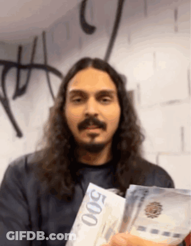 A Man With Long Hair And A Beard Is Holding Up A 500 Bill GIF