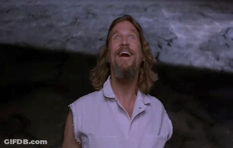 A Man With Long Hair And A Beard Is Laughing And Looking Up At The Sky . GIF