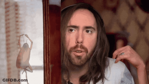 A Man With Long Hair And A Beard Is Looking At A Statue Of A Woman GIF