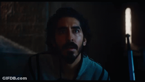 A Man With Long Hair And A Beard Is Looking At Something GIF