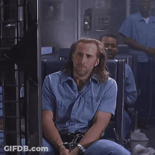 A Man With Long Hair And A Beard Is Looking At Something GIF