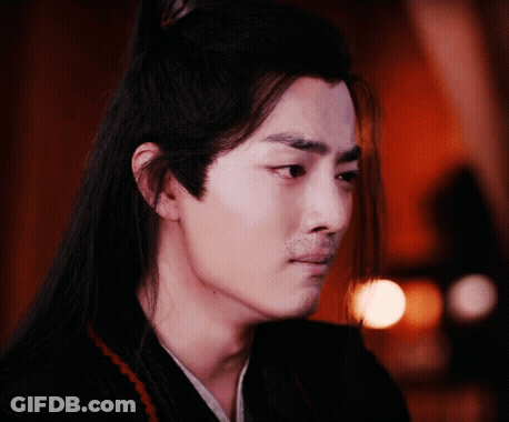 A Man With Long Hair And A Beard Is Looking At The Camera . GIF