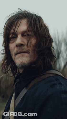 A Man With Long Hair And A Beard Is Looking At The Camera GIF