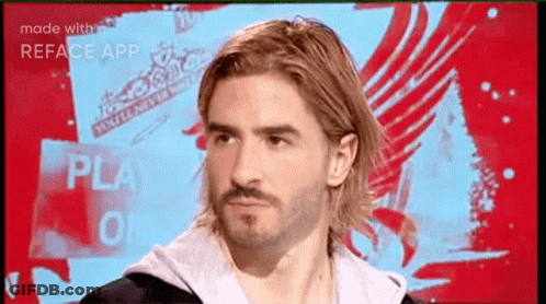 A Man With Long Hair And A Beard Is Looking At The Camera GIF