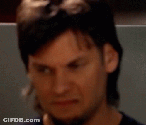 A Man With Long Hair And A Beard Is Making A Face GIF