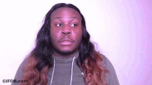 A Man With Long Hair And A Beard Is Making A Face . GIF