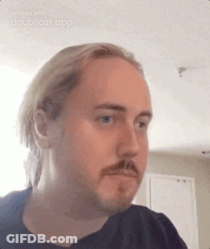 A Man With Long Hair And A Beard Is Making A Funny Face . GIF