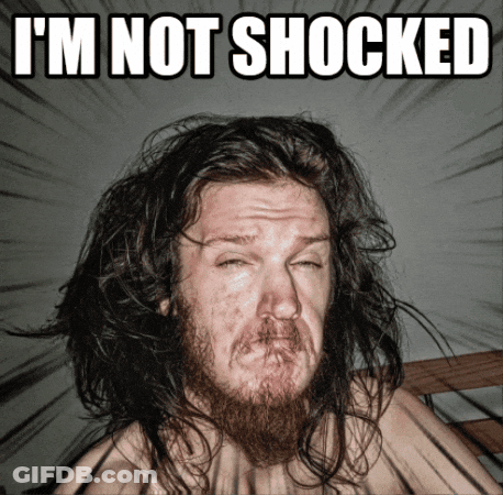 A Man With Long Hair And A Beard Is Making A Funny Face With The Words I 'M Not Shocked Above Him GIF