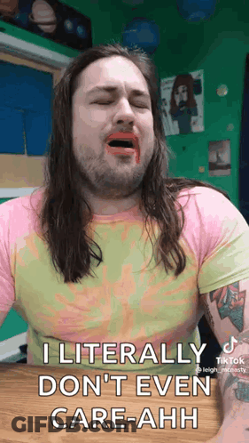 A Man With Long Hair And A Beard Is Sitting At A Table With His Mouth Open And Lipstick On His Face . GIF