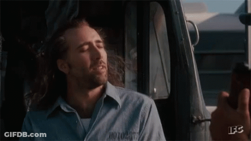 A Man With Long Hair And A Beard Is Sitting In A Car With His Eyes Closed And Smiling . GIF
