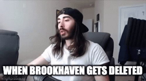A Man With Long Hair And A Beard Is Sitting In A Chair With A Microphone . GIF