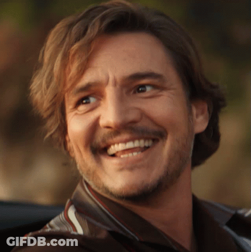 A Man With Long Hair And A Beard Is Smiling For The Camera GIF