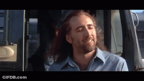 A Man With Long Hair And A Beard Is Smiling While Sitting In A Bus GIF