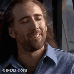 A Man With Long Hair And A Beard Is Smiling With His Eyes Closed While Sitting On A Bus . GIF