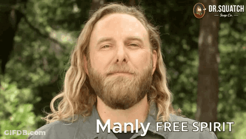 A Man With Long Hair And A Beard Is Smiling With The Words Manly Free Spirit Below Him GIF