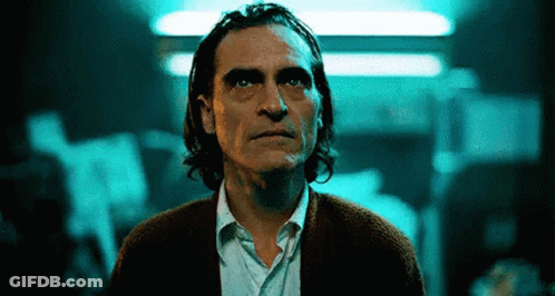 Man With Long Hair And Beard Standing In Dark Room GIF