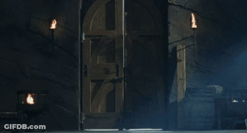 A Man With Long Hair And A Beard Is Standing In A Dark Room With His Arms Outstretched GIF