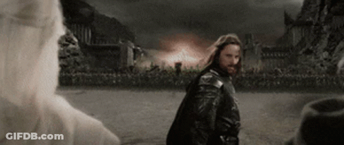 A Man With Long Hair And A Beard Is Standing In A Field In Front Of A Castle . GIF
