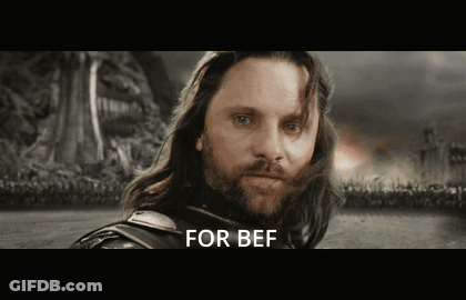 A Man With Long Hair And A Beard Is Standing In A Field With The Words For Bef Written Below Him GIF