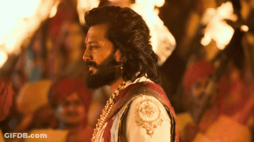 A Man With Long Hair And A Beard Is Standing In Front Of A Crowd GIF
