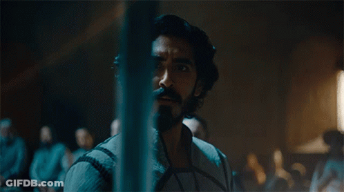 A Man With Long Hair And A Beard Is Standing In Front Of A Crowd GIF