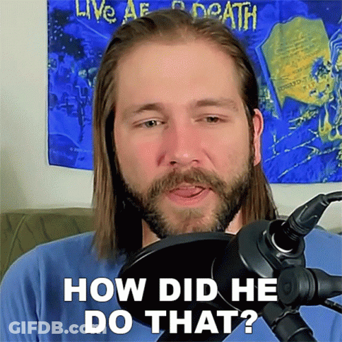 A Man With Long Hair And A Beard Is Standing In Front Of A Microphone Asking How Did He Do That GIF