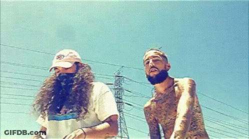 A Man With Long Hair And A Beard Is Standing Next To Another Man With A Beard GIF