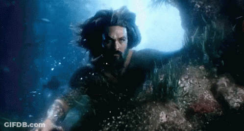 A Man With Long Hair And A Beard Is Swimming Underwater . GIF