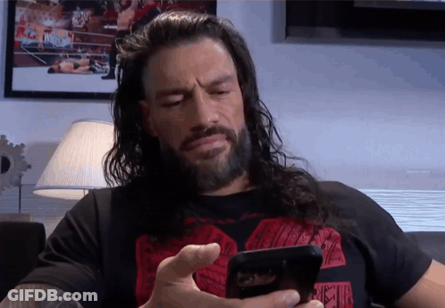 A Man With Long Hair And A Beard Is Using A Cell Phone GIF