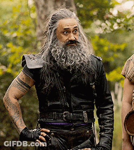 A Man With Long Hair And A Beard Is Wearing A Black Leather Jacket GIF