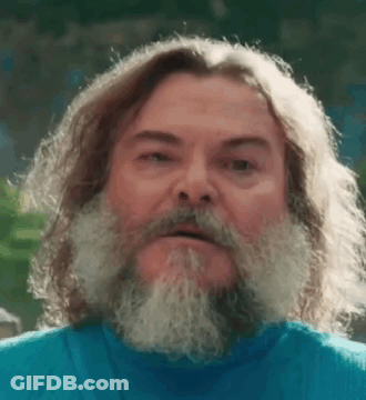 A Man With Long Hair And A Beard Is Wearing A Blue Shirt And Looking At The Camera . GIF