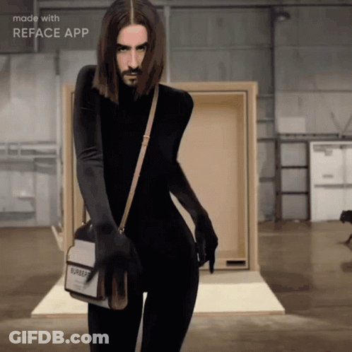 A Man With Long Hair And A Beard Is Wearing A Burberry Bag GIF