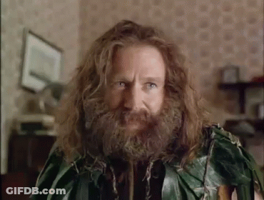 A Man With Long Hair And A Beard Is Wearing A Green Leafy Outfit . GIF