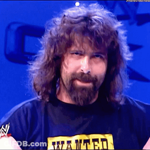 A Man With Long Hair And A Beard Is Wearing A Wanted T-Shirt GIF