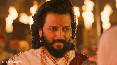 A Man With Long Hair And A Beard Is Wearing A White Shirt And A Red Scarf GIF