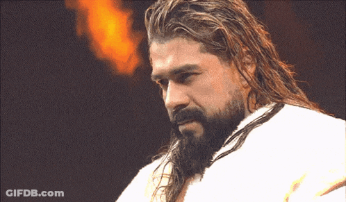 A Man With Long Hair And A Beard Is Wearing A White Towel GIF
