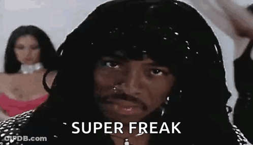 A Man With Long Hair And A Beard Is Wearing A Wig And Earrings And Says `` Super Freak '' . GIF
